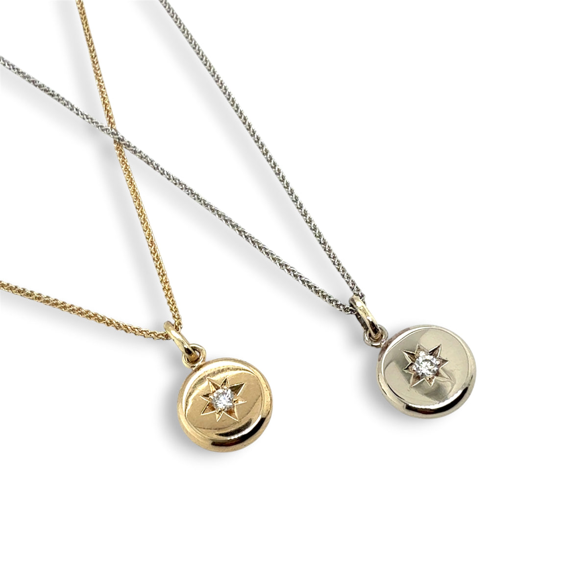 Two round pendant necklaces on white backgrounds, one in yellow gold and one in silver, each featuring a small star set detail with a diamond  gemstone.